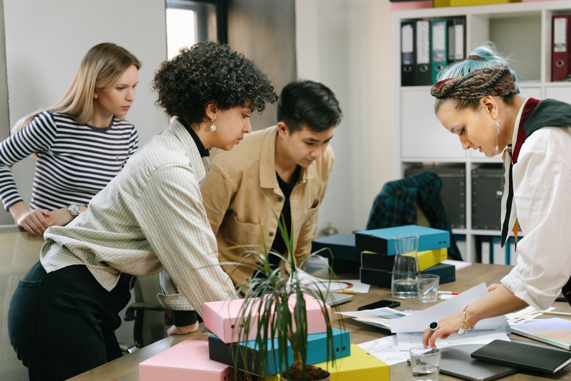A team collaborating over documents in an office — the kind of business where coordination is the bottleneck.
