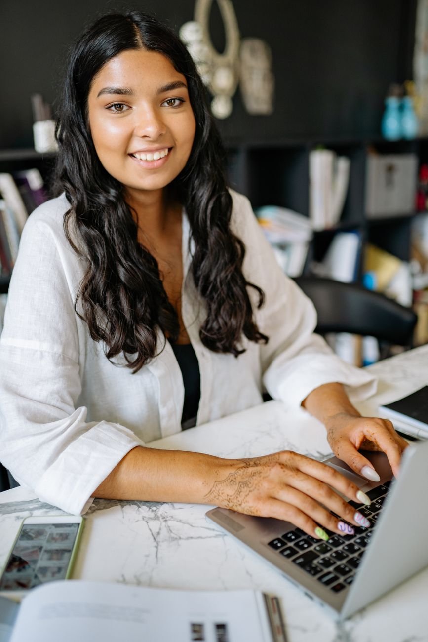 Confident small business owner smiling at laptop — the kind of person who has their systems sorted.